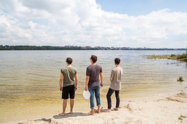 Männliche Freunde, die Fluss betrachtend stehen