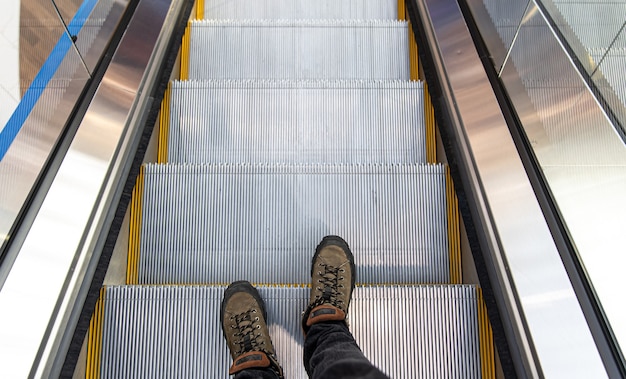 Männliche Füße auf der Rolltreppe, Ansicht von oben.