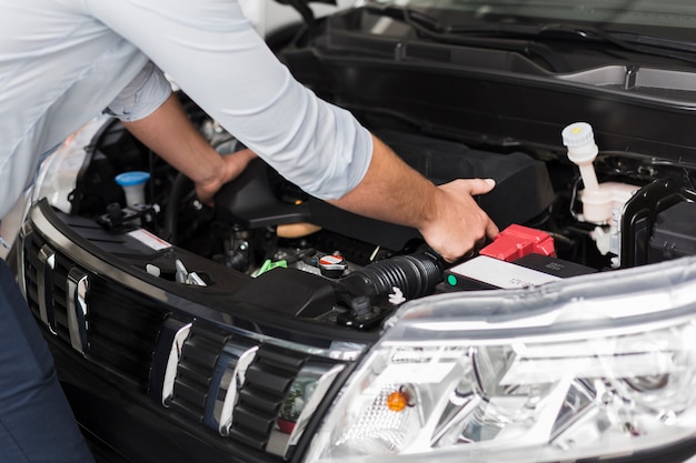 Männliche Hände, die Automotor herausnehmen