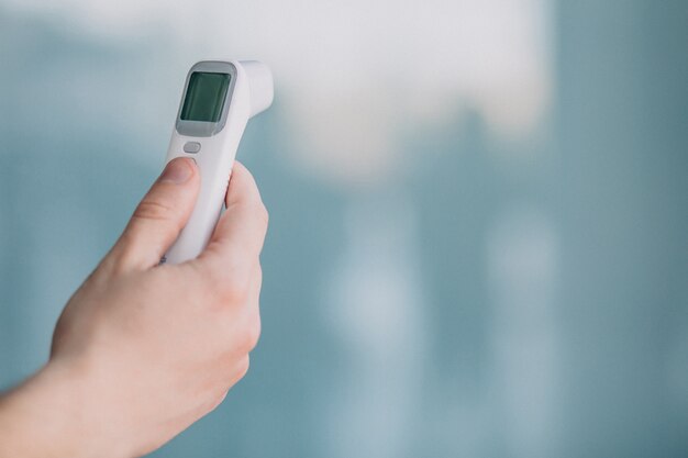 Männliche Hand, die Elektrothermometer hält