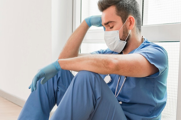 Männliche Krankenschwester, die nach einer langen Schicht eine Pause macht