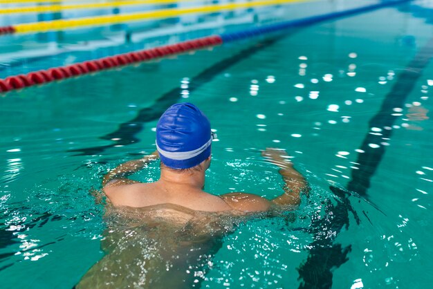 Männliche Schwimmen der hinteren Ansicht im Pool