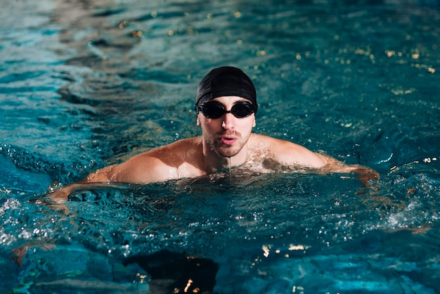 Männliche Schwimmerpraxis des hohen Winkels am Becken