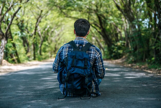 Männliche Touristen, die eine Maske tragen und einen Rucksack auf der Straße tragen.