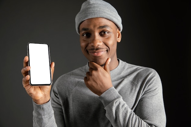 Kostenloses Foto männliche tragende kappe, die telefon hält