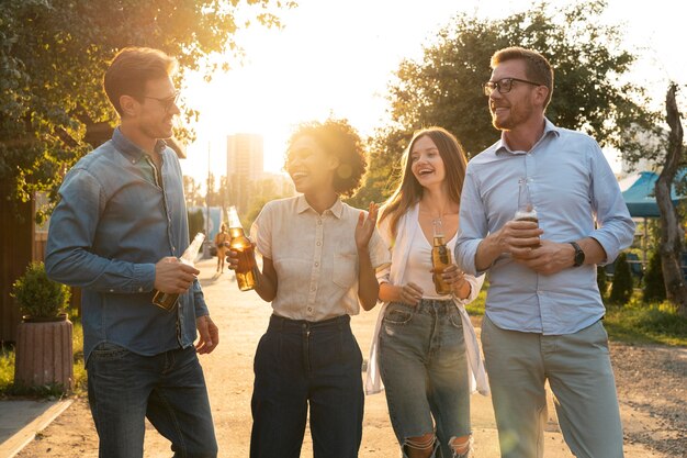 Männliche und weibliche Freunde verbringen Zeit zusammen im Freien und trinken Bier