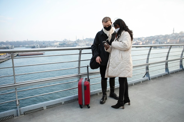 Männliche und weibliche Touristen, die ihr Smartphone im Freien überprüfen