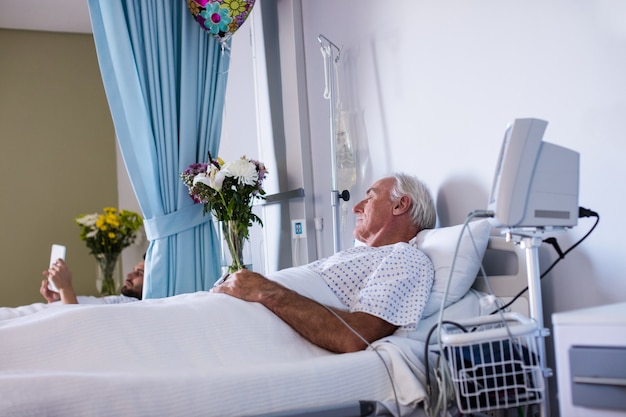 Kostenloses Foto männlicher älterer patient, der sich in der station entspannt