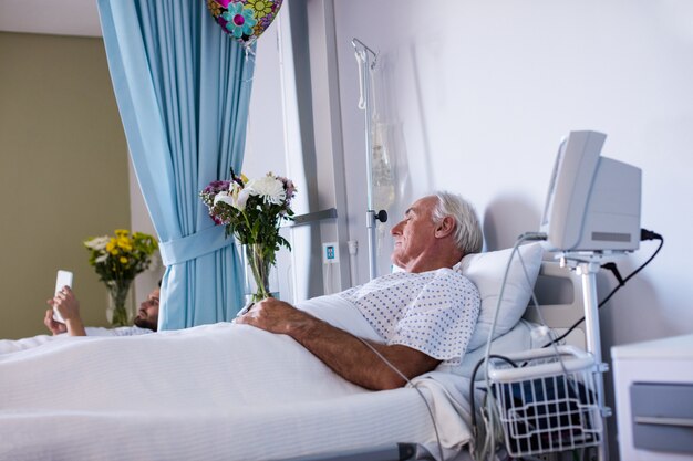 Männlicher älterer Patient, der sich in der Station entspannt