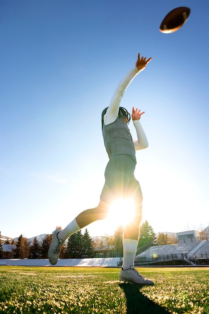 Männlicher amerikanischer Fußballspieler im einheitlichen Training auf dem Feld