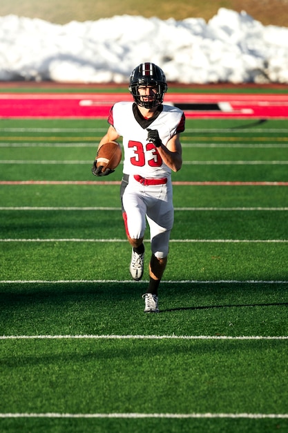 Männlicher amerikanischer Fußballspieler in Uniform auf dem Feld