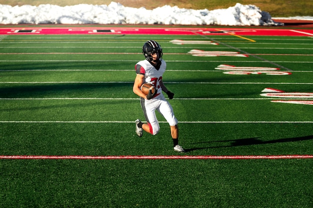 Kostenloses Foto männlicher amerikanischer fußballspieler in uniform auf dem feld