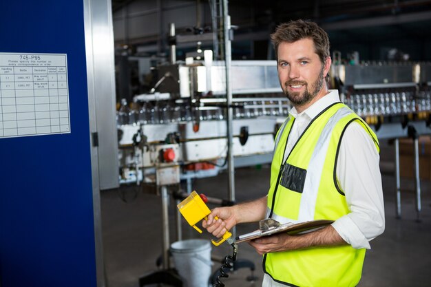 Männlicher Arbeiter, der Maschinen an der Saftfabrik benutzt