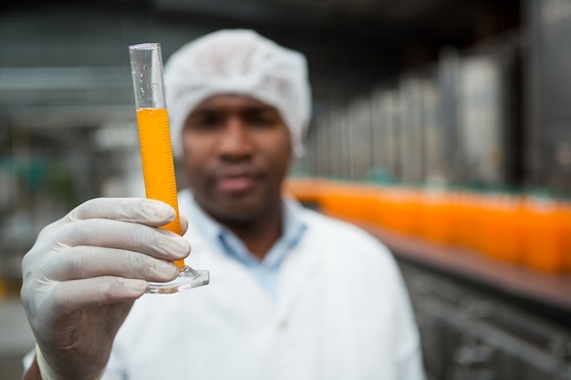 Kostenloses Foto männlicher arbeiter, der saft in der fabrik prüft