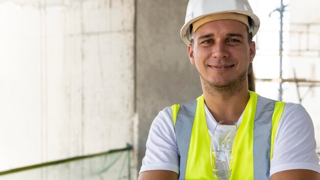 Männlicher Arbeiter im Bau, der Schutzausrüstung trägt