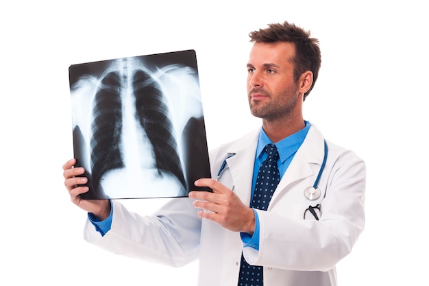 Männlicher Arzt, der Röntgenbild untersucht