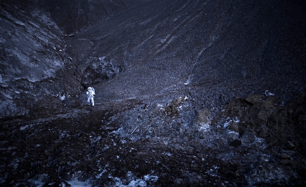 Männlicher Astronaut, der nachts während einer Weltraummission auf einem unbekannten Planeten erforscht