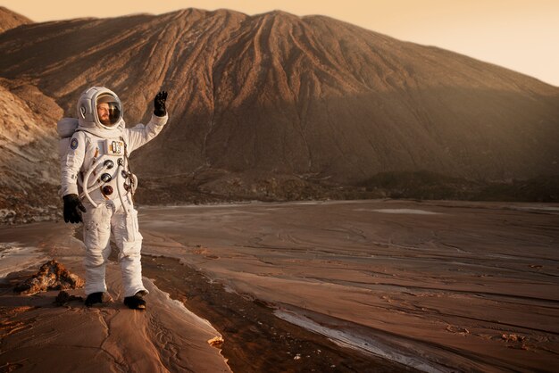 Männlicher Astronaut, der seine Augen während einer Weltraummission auf einem anderen Planeten vor der Sonne schützt