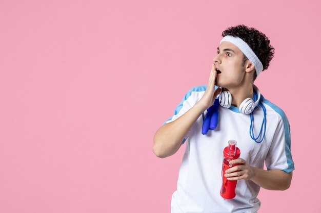 Männlicher Athlet der Vorderansicht in der Sportkleidung mit der Flasche Wasser