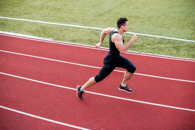 Männlicher Athlet kommt zur Ziellinie auf Rennstrecke während der Trainingseinheit an