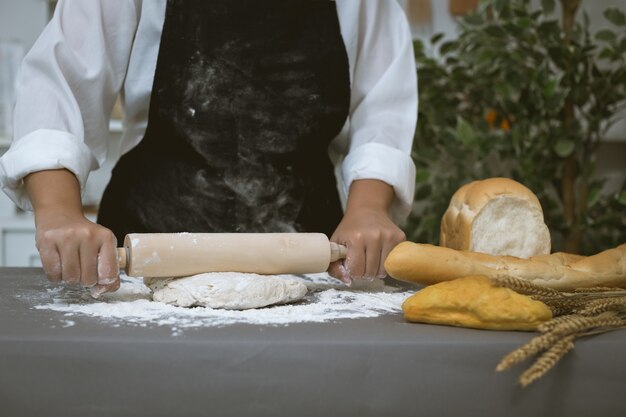 Männlicher Bäcker bereitet Brot mit Mehl zu