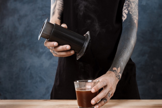 Männlicher Barista, der Kaffee braut. Alternative Methode Aeropresse.