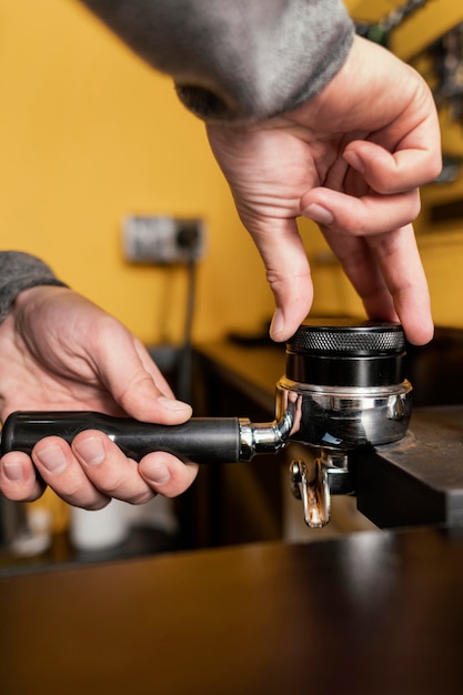 Männlicher Barista mit professioneller Kaffeemaschinenschale