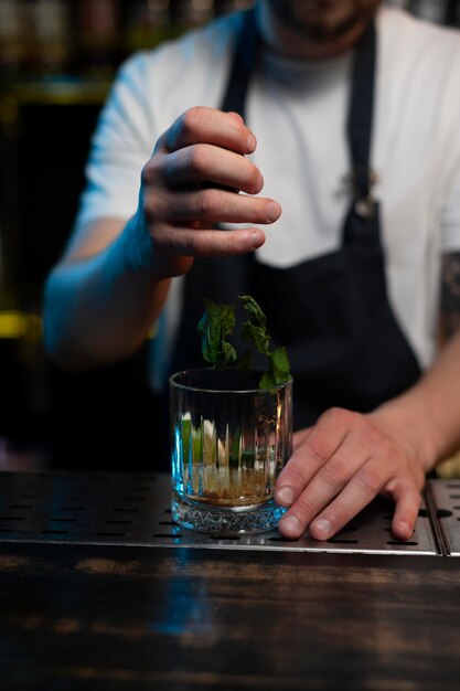 Männlicher Barkeeper, der einen köstlichen Cocktail macht