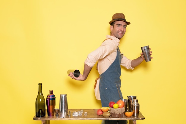 Männlicher Barkeeper in der Vorderansicht, der mit Shakern arbeitet und Getränke an der gelben Wand zubereitet, trinkt Alkohol-Bar-Club-Männchen