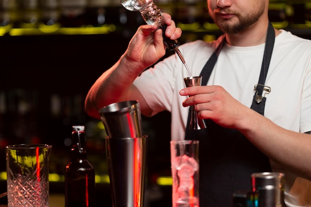 Männlicher Barkeeper macht einen Cocktail mit einem Shaker