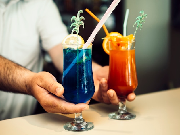 Männlicher Barmixer, der exotische Cocktails dient