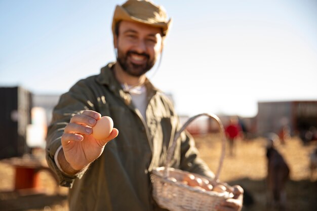 Männlicher Bauer, der Ei von seiner Farm hält