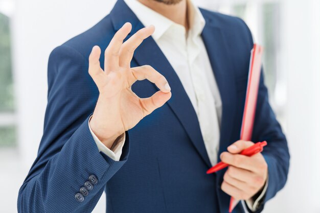 Bewerbung: Eine Hand, die ein Zwischenzeugnis mit ausgezeichneter Bewertung hält.