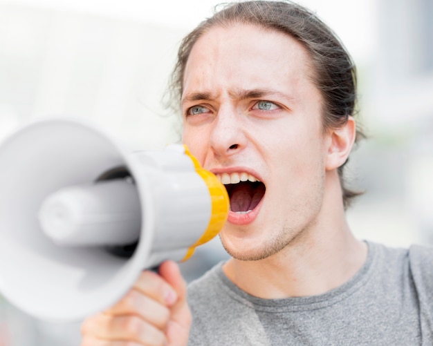 Kostenloses Foto männlicher demonstrant, der in megaphon-nahaufnahme schreit