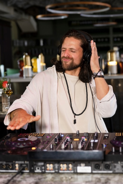 Männlicher DJ, der sich um die Musikunterhaltung auf einer Party kümmert