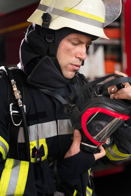 Männlicher Feuerwehrmann am Bahnhof in Anzug und Helm