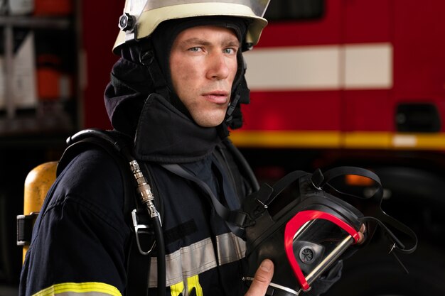 Männlicher Feuerwehrmann am Bahnhof in Anzug und Helm