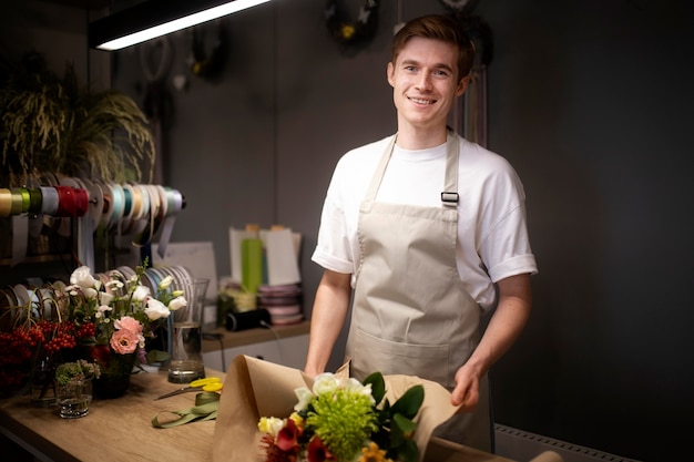 Männlicher Florist macht einen schönen Blumenstrauß