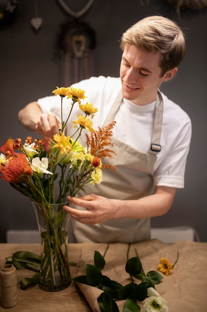 Kostenloses Foto männlicher florist macht einen schönen blumenstrauß