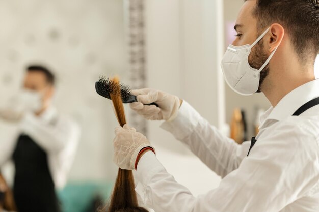 Männlicher Friseur bei der Arbeit während der Coronavirus-Epidemie