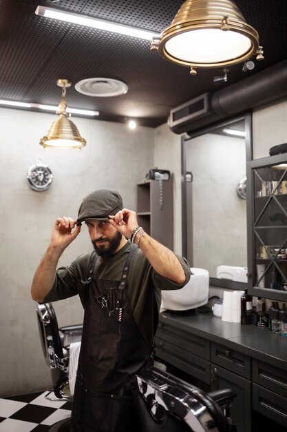 Männlicher Friseur, der in seinem Geschäft sitzt