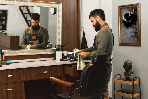 Männlicher Friseur, der Instrumente für Arbeit im Friseursalon vorbereitet