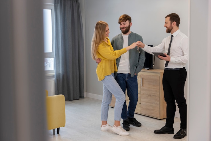 Kostenlose Foto männlicher immobilienmakler, der geschäfte macht und potenziellen kaufpaaren haus zeigt