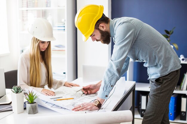 Männlicher Ingenieurzeichnungsplan auf blauem Druck mit Architektenausrüstung