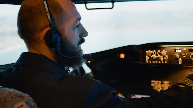 Männlicher Kapitän, der ein Flugzeug mit Motordrossel und Netzschalter auf dem Armaturenbrett im Cockpit steuert. Festlegen der Höhen- und Längengrade zum Starten und Fliegen von Flugzeugen. Handschuss. Nahansicht.