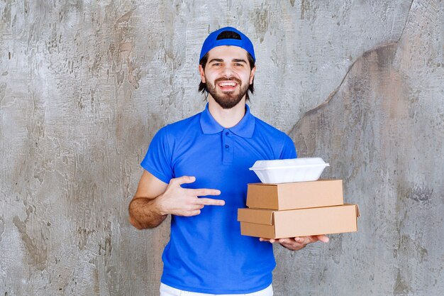 Männlicher Kurier in blauer Uniform mit Karton- und Plastikboxen