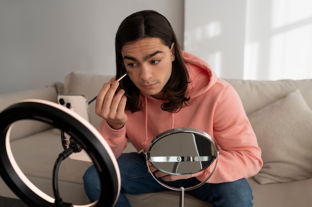 Männlicher Make-up-Künstler, der sich selbst schminkt