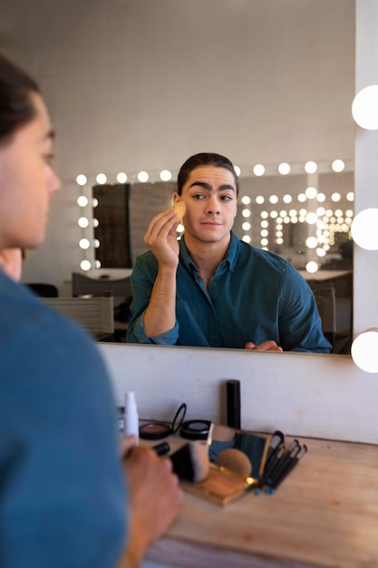 Kostenloses Foto männlicher make-up-künstler, der sich selbst schminkt