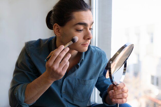 Männlicher Make-up-Künstler, der sich selbst schminkt