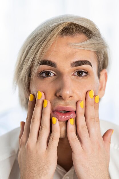 Männlicher Make-up-Look und gelbe Nägel